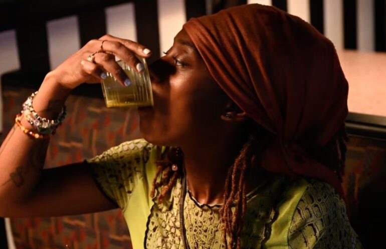 An African American woman drinking Kratom
