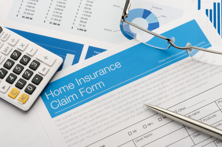 Home insurance claim form on a desk with paperwork.