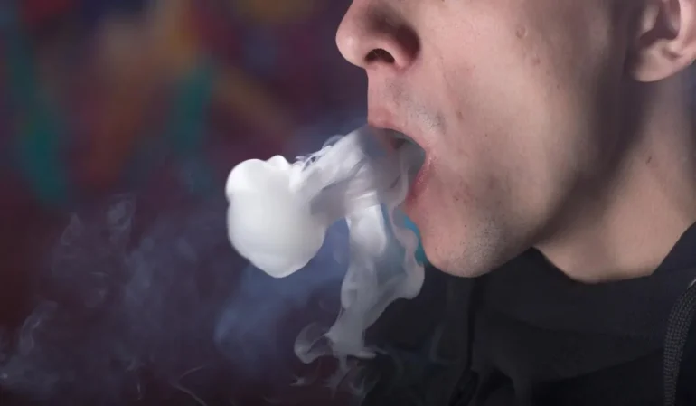 Young Man Vaping. Concept for Leaks in Vape Devices